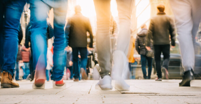 Crowd of people walking in motion in downtown rush hour
