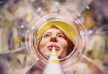 Coffee to Fonds statt Coffee to go Sich aus einem leeren Glas entlang eines Strohhalms auf ein weibliches Gesicht