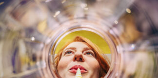 Sich aus einem leeren Glas entlang eines Strohhalms auf ein weibliches Gesicht