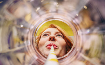 Sich aus einem leeren Glas entlang eines Strohhalms auf ein weibliches Gesicht