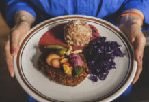 Eine Frau hält einen Teller mit einem Gericht aus "Meine Küche"