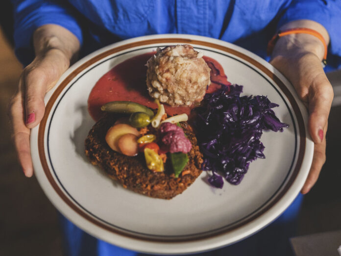 Eine Frau hält einen Teller mit einem Gericht aus 