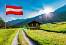 Wanderweg in den österreichischen Alpen mit einer Almhütte