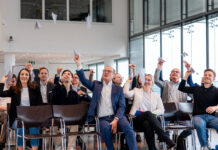 Workshop-Teilnehmer werfen Papierflieger in die Luft