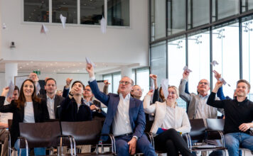 Workshop-Teilnehmer werfen Papierflieger in die Luft