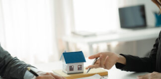 Symbolbild: Zwei Personen an einem Tisch, Vertragsunterzeichnung, Immobilienfinanzierung, Immobilienkauf
