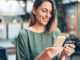 E-Commerce: Das Smartphone als Einkaufswagen Frau mit einem Smartphone und einer Kreditkarte in der Hand