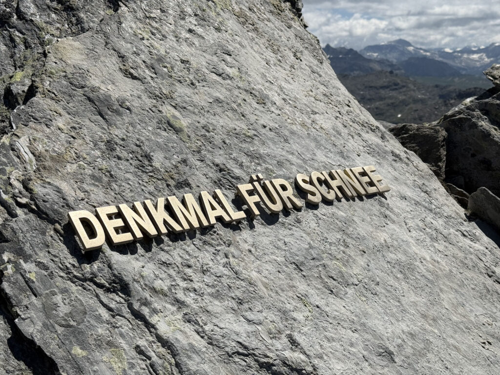 Denkmal für Schnee-Metall-Schriftzug am Berg