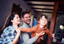 Raiffeisen FondsPension: Vorsorge, die mit dem Leben mitgeht Carefree parents having fun while playing with their small daughter at home. Focus is on girl.