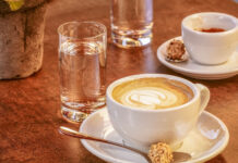 Kaffee: Weit mehr als Wachmacher Ein Cappuccino und ein Espresso auf einem Tisch mit zwei Gläsern Wasser