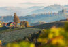 Colorful autumn landscape in the mountains with Grape hills and morning fog glowing by sun. Gamlitz, Austria, Europe. Awesome nature Background. Concept ideal resting place