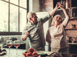 Älteres Paar tanzt fröhlich in der Küche. Symbolbild Zusatzpension, Pension, Ruhestand