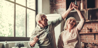 Älteres Paar tanzt fröhlich in der Küche. Symbolbild Zusatzpension, Pension, Ruhestand