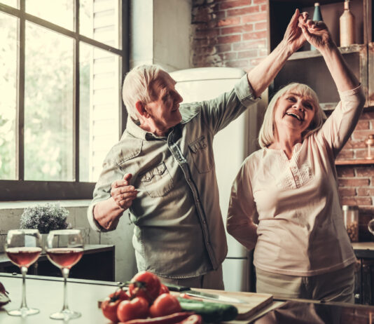 Älteres Paar tanzt fröhlich in der Küche. Symbolbild Zusatzpension, Pension, Ruhestand