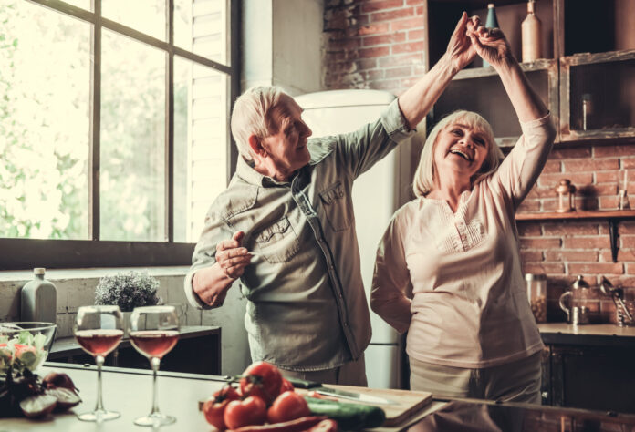 Älteres Paar tanzt fröhlich in der Küche. Symbolbild Zusatzpension, Pension, Ruhestand