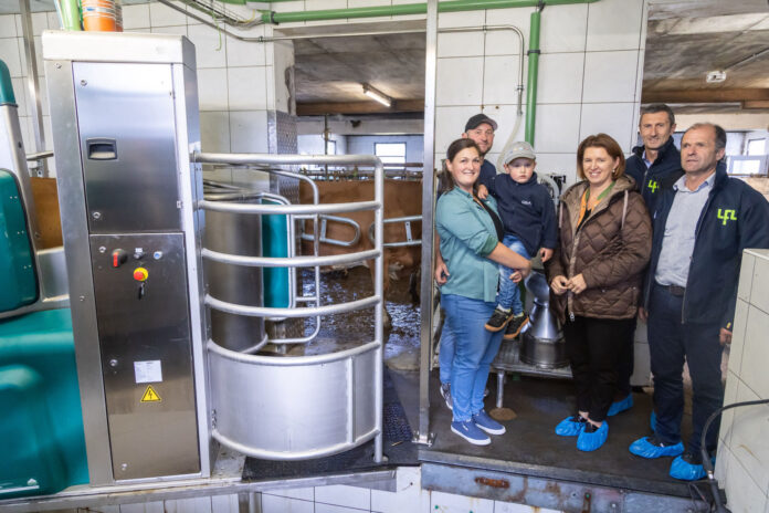 Susanne und Werner Aistleithner mit Sohn Alexander, Michaela Langer-Weninger, Markus Koblmüller und Thomas Hartl neben dem Melkroboter im Stall