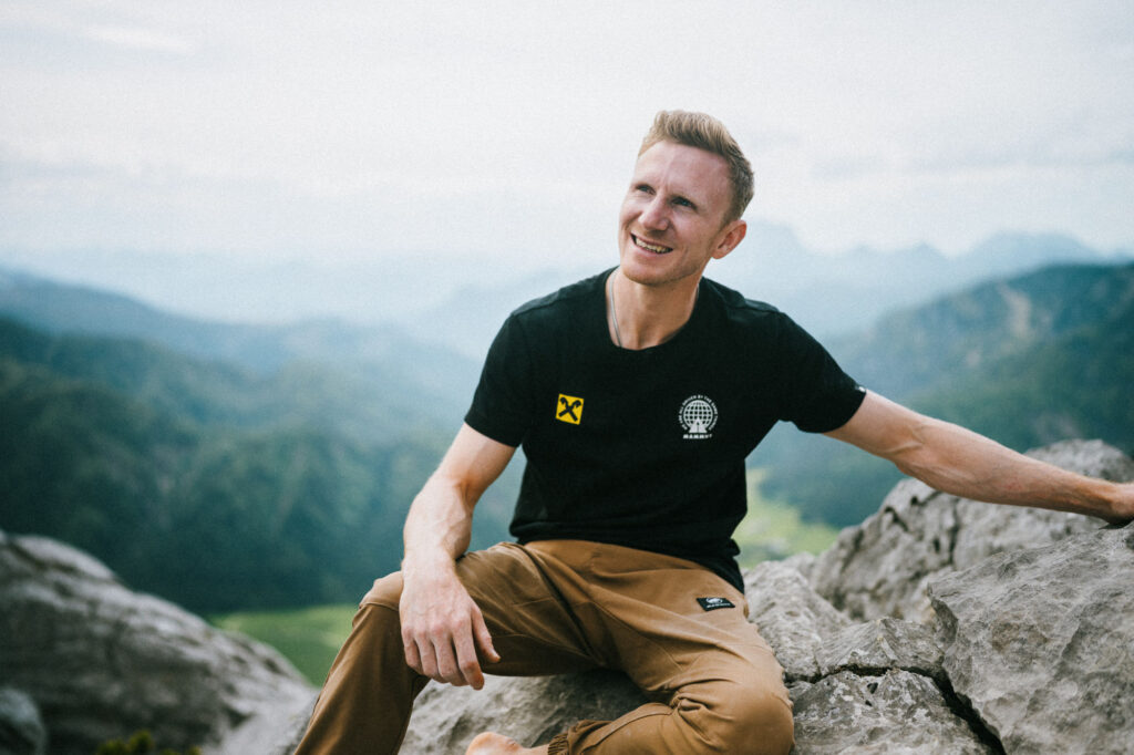 Jakob Schubert auf einem Fels sitzend
