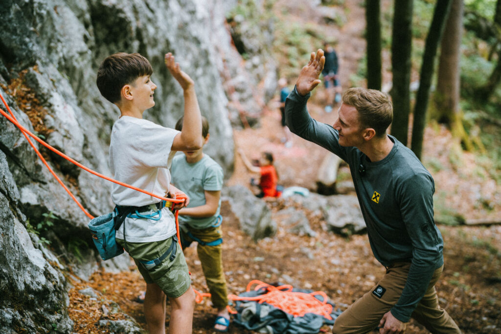 Jakob Schubert gibt einem Teilnehmer seines Klettercamps ein highfive