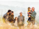 Happy multi-generation family talking while taking a walk on the field. Copy space.