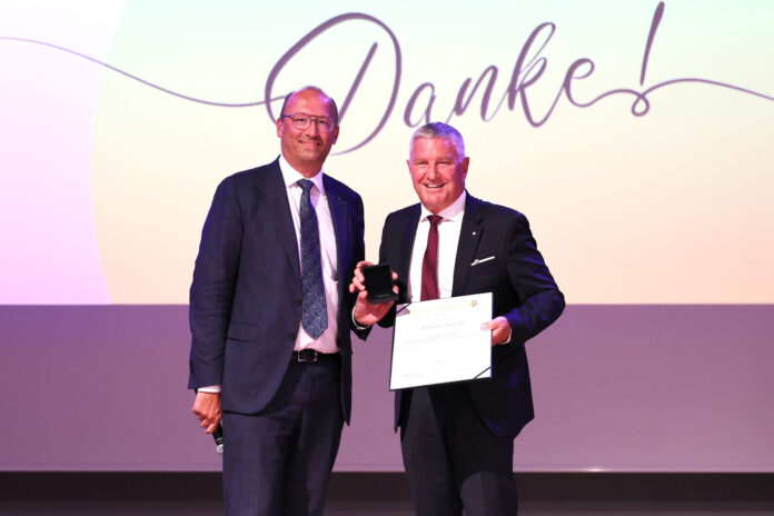 Reinhard Schwendtbauer überreicht Johann Fröschl die Silberne Raiffeisen-Plakette.
